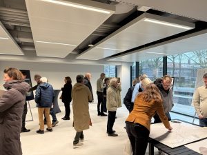 Bezoekers van een inloopbijeenkomst bekijken op hun gemak verschillende informatiepanelen