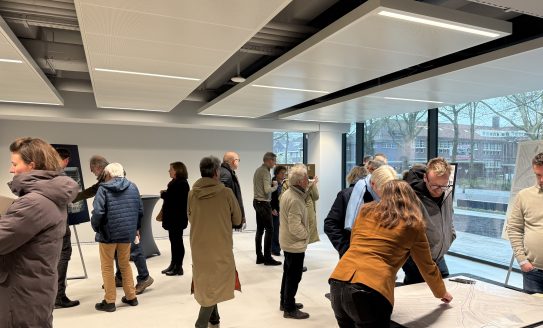 Bezoekers van een inloopbijeenkomst bekijken op hun gemak verschillende informatiepanelen